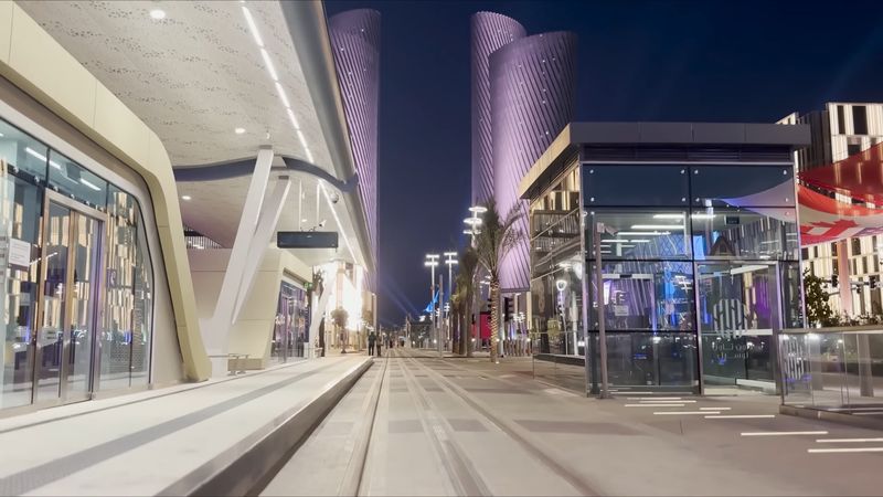 Lusail Boulevard at night, with the Lusail Plaza towers lit in violet above the promenade
